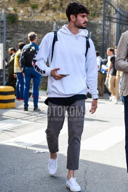 Men's spring and fall coordinate and outfit with plain white hoodie, plain gray cargo pants, and white low-cut sneakers.