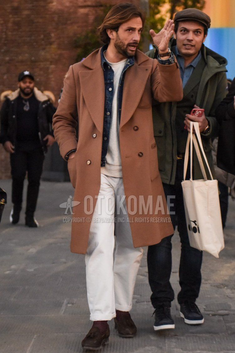 Men's fall/winter outfit with solid beige chester coat, solid blue denim jacket, solid white sweatshirt, solid white cotton pants, solid brown socks, suede brown tassel loafer leather shoes.