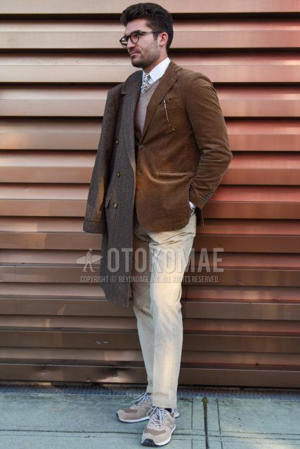 Men's fall/winter outfit with gray checked Ulster coat, plain brown tailored jacket, plain beige sweater, plain white shirt, plain beige winter pants (corduroy, velour), plain black socks, and New Balance 574 gray low-cut sneakers. The way to dress.
