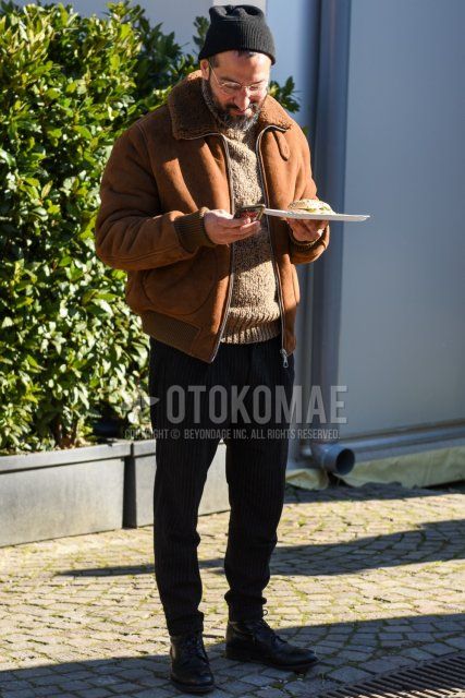Men's fall/winter outfit/coordination with solid black knit cap, solid gold glasses, solid brown leather jacket (not riders), solid beige turtleneck knit, gray striped slacks, gray striped pleated pants, and black boots.