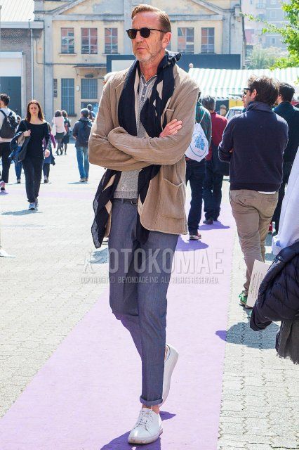 Men's spring/fall outfit with plain black sunglasses in Boston, plain beige scarf/stall, plain beige cardigan, henley neck grey top/inner t-shirt, plain black leather belt, plain grey slacks, and white low-cut sneakers.
