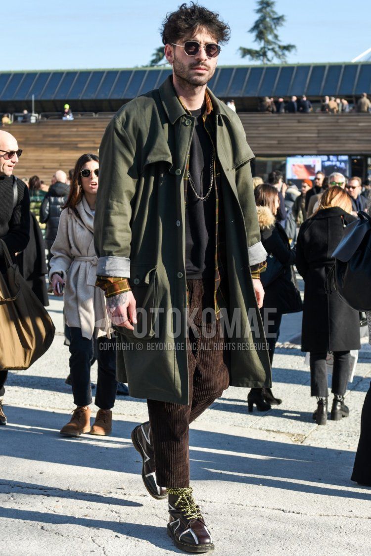 Men's fall/winter coordinate and outfit with plain silver sunglasses, plain olive green trench coat, multi-colored checked shirt, plain black t-shirt, plain brown winter pants (corduroy,velour), plain brown cropped pants and brown boots.