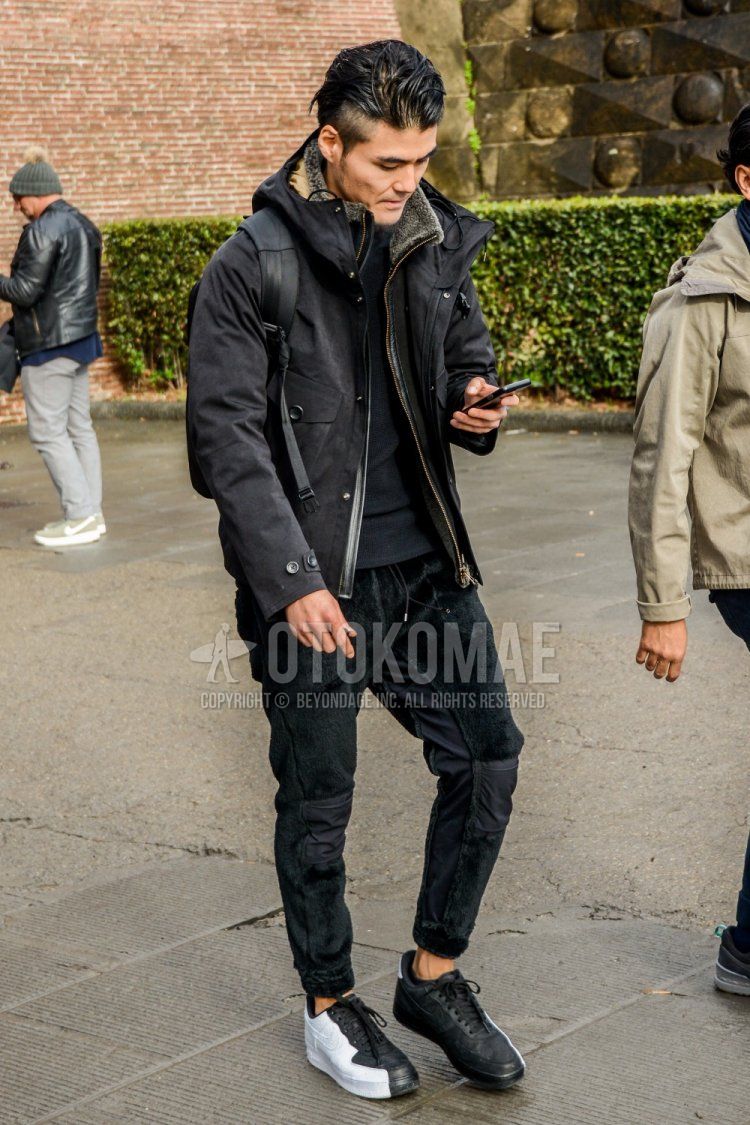 Men's fall/winter outfit with plain black mountain parka, plain black t-shirt, plain black easy pants, plain black jogger pants/ribbed pants, and Nike Air Force One white/black low-cut sneakers.