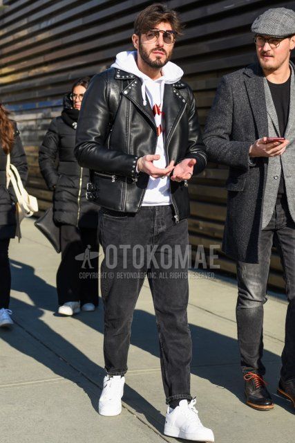 Men's fall/winter coordinate and outfit with plain black sunglasses, plain black rider's jacket, white graphic hoodie, plain gray denim/jeans, and white low-cut sneakers.