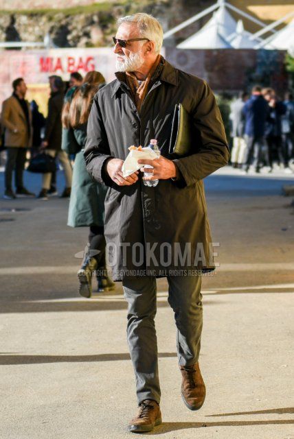 Men's fall/winter outfit with solid black sunglasses, solid beige scarf/stall, solid black stainless steel collar coat, solid gray chinos, and suede brown wingtip leather shoes.