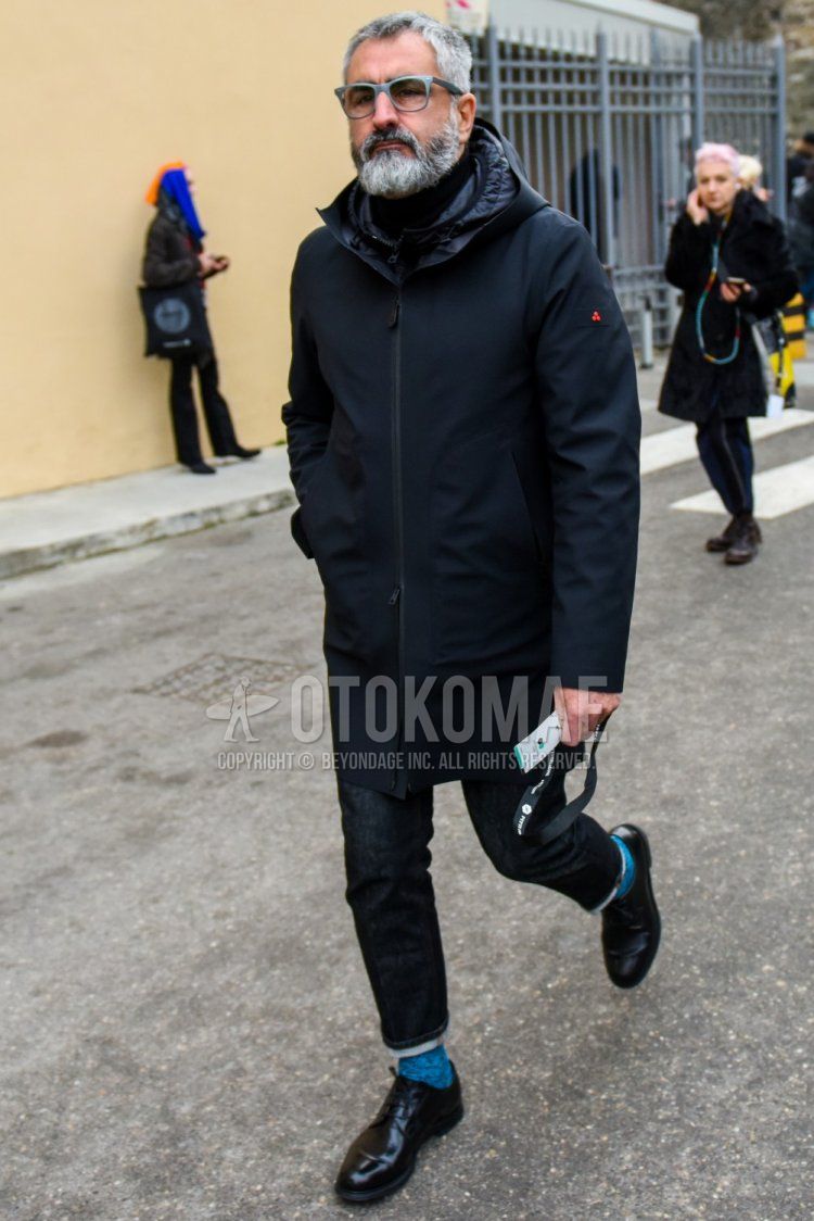 Men's winter coordinate and outfit with solid color glasses, solid color black mountain parka, solid color navy denim/jeans, solid color light blue socks, and black straight tip leather shoes.