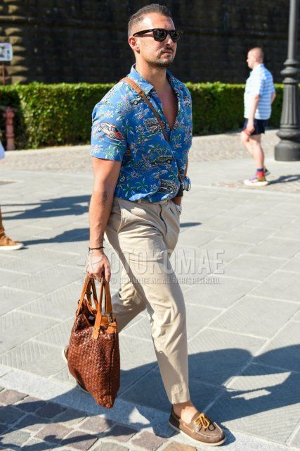 Men's spring/summer coordinate and outfit with brown tortoiseshell sunglasses, blue top/inner shirt, solid beige chinos, solid beige cropped pants, brown moccasins/deck shoes leather shoes, solid brown briefcase/handbag.