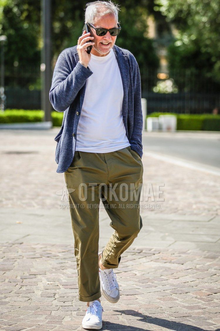Men's spring and summer coordinate and outfit with plain black sunglasses, blue outer tailored jacket, plain white t-shirt, plain olive green cargo pants, and white sneakers.