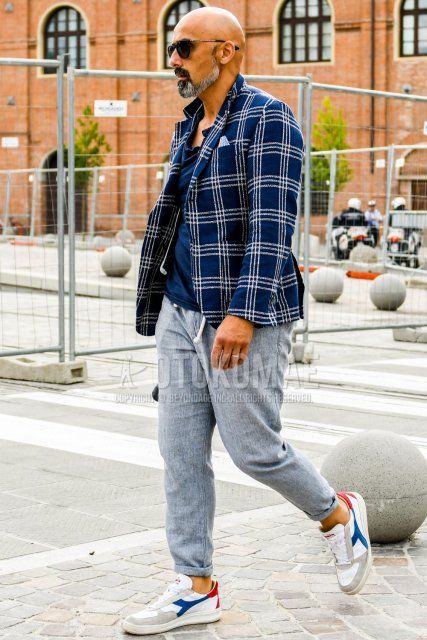 Men's spring, summer, and fall coordinate and outfit with plain sunglasses, navy check tailored jacket, plain navy t-shirt, plain gray easy pants, and white low-cut sneakers by Diadora.