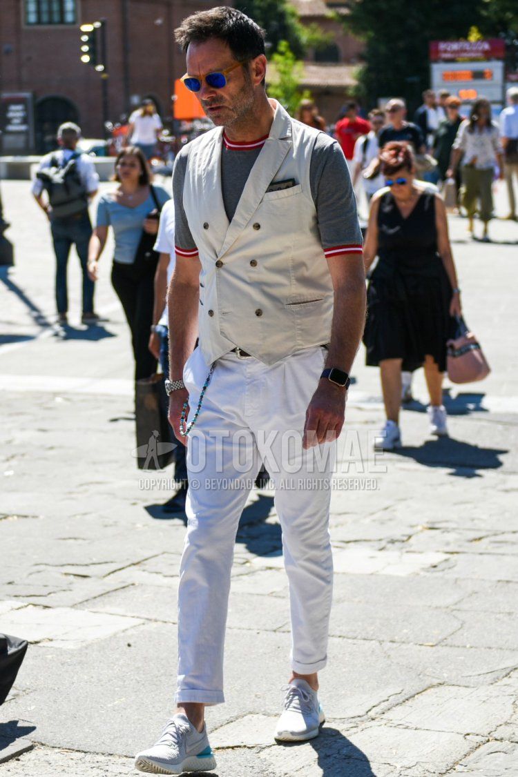Summer men's coordinate and outfit with plain beige sunglasses, plain white gilet, knit plain gray t-shirt, plain black leather belt, plain white cotton pants, and Nike gray low-cut sneakers.
