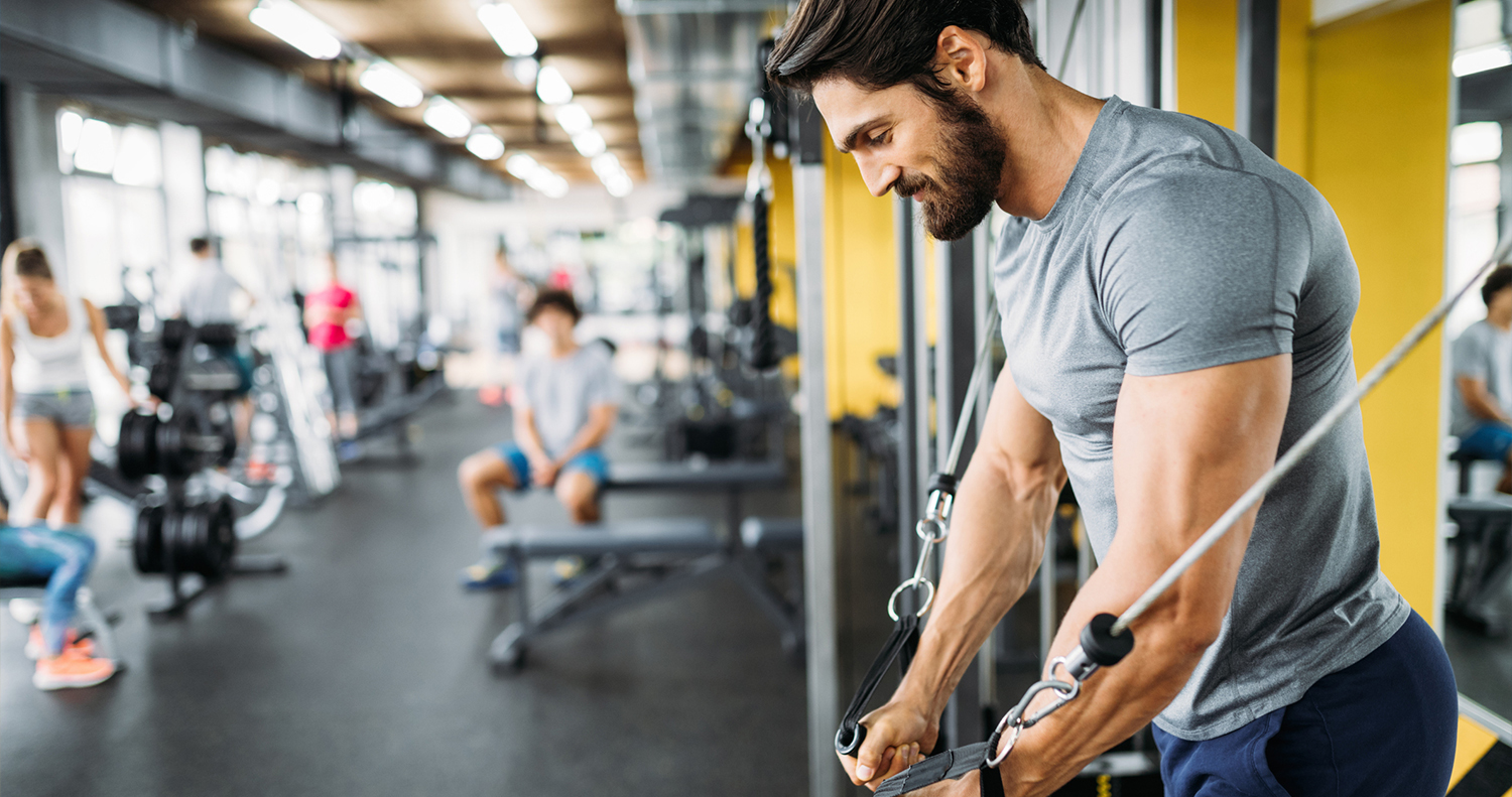 Muscle trainer. Спорт. Избежание травм в тренажерном зале. Man doing Fitness in Fitness Hall.