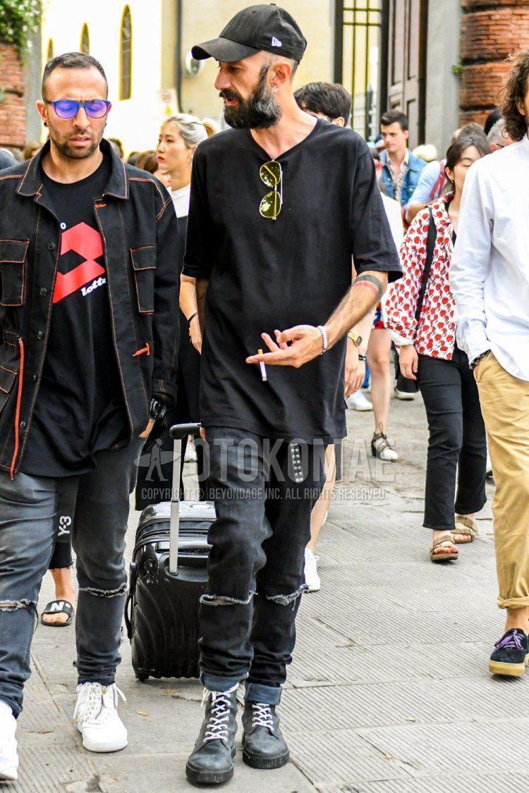 Summer men's coordinate and outfit with plain black baseball cap from New Era, plain yellow sunglasses, plain black t-shirt, plain black leather belt, plain black damaged jeans, and gray boots.