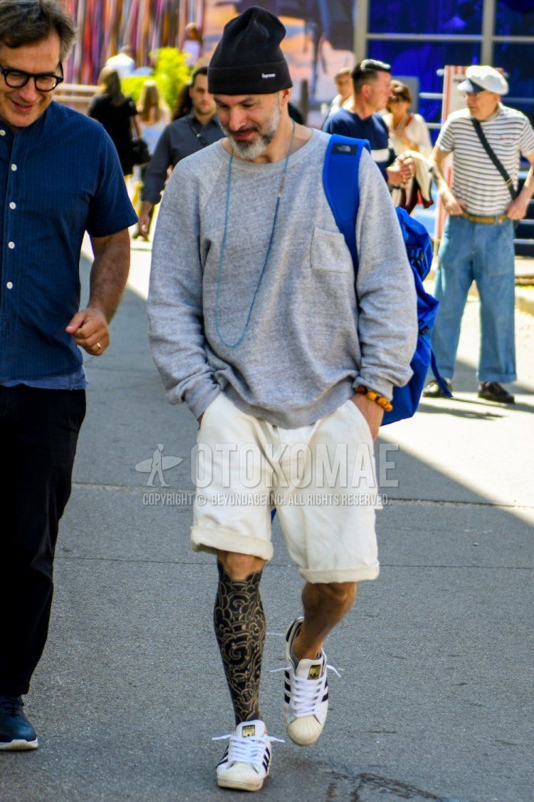 Spring and fall men's coordinate and outfit with Supreme plain black knit cap, plain gray sweatshirt, plain white shorts, and Adidas Superstar white low-cut sneakers.
