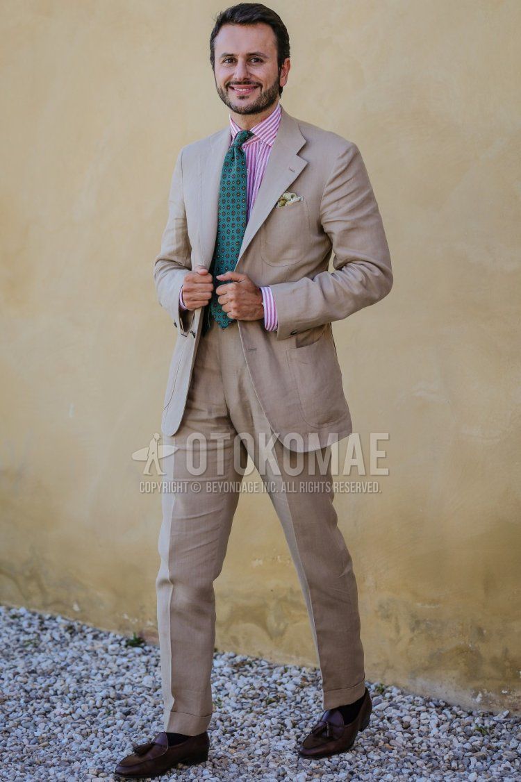 Men's spring/summer coordinate and outfit with pink striped shirt, brown tassel loafer leather shoes, plain beige suit and green small print tie.