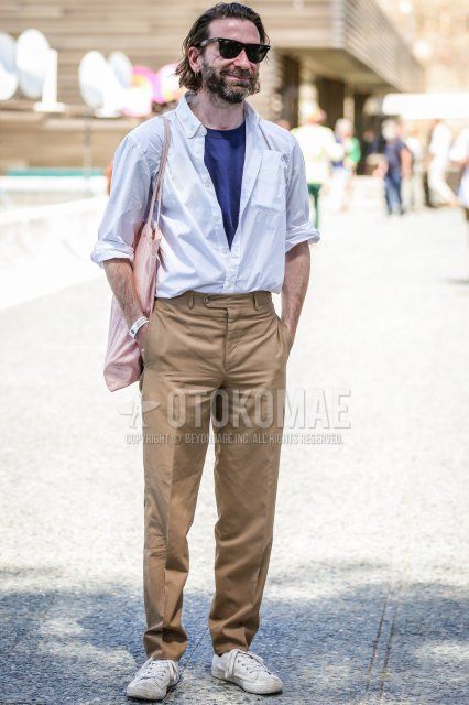 Men's spring/summer coordinate and outfit with plain black sunglasses, plain white shirt, plain navy/blue t-shirt, plain brown chinos, white sneakers, and plain pink tote bag.