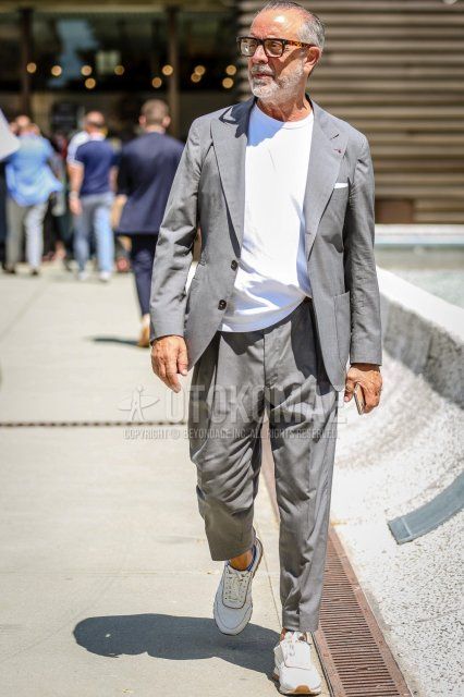Men's spring/summer coordinate and outfit with brown tortoiseshell glasses, plain white T-shirt, white sneakers, and plain gray suit.