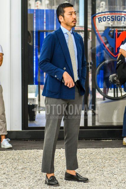 Men's spring, summer, and fall coordinate and outfit with plain navy tailored jacket, plain light blue shirt, plain gray ankle pants, black coin loafer leather shoes, and plain beige tie.