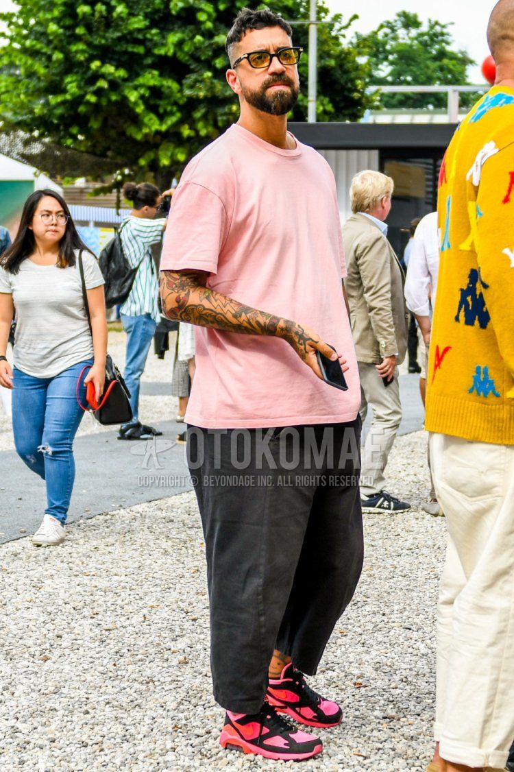 Summer men's coordinate and outfit with solid color sunglasses, solid color red t-shirt, solid color gray denim/jeans, and Comme des Garcons Homme Plus Nike Air Max 180 pink low-cut sneakers.