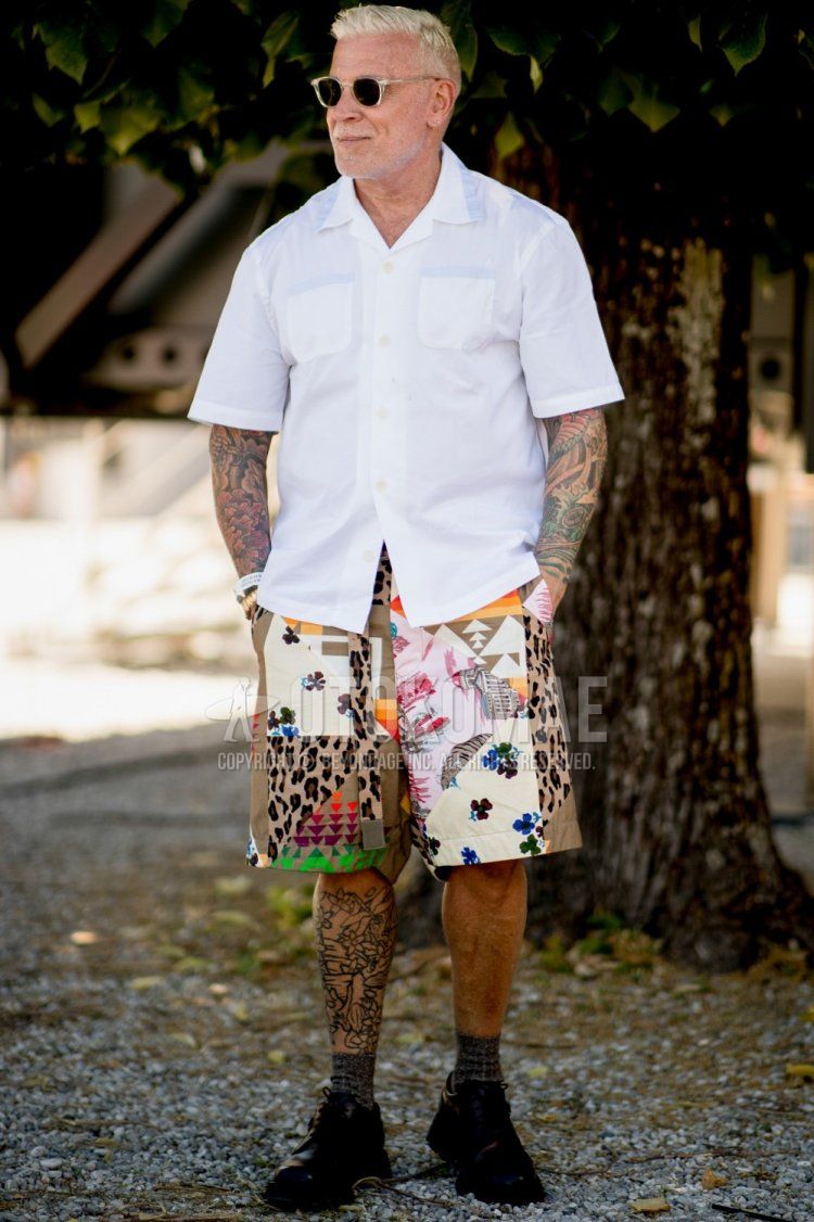Men's spring/summer coordinate and outfit with clear plain sunglasses, plain white shirt, multi-colored bottoms shorts, plain gray socks, and black plain toe leather shoes.