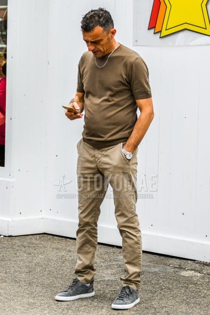 Men's summer coordinate and outfit with plain brown t-shirt, plain beige chinos, and gray low-cut sneakers.