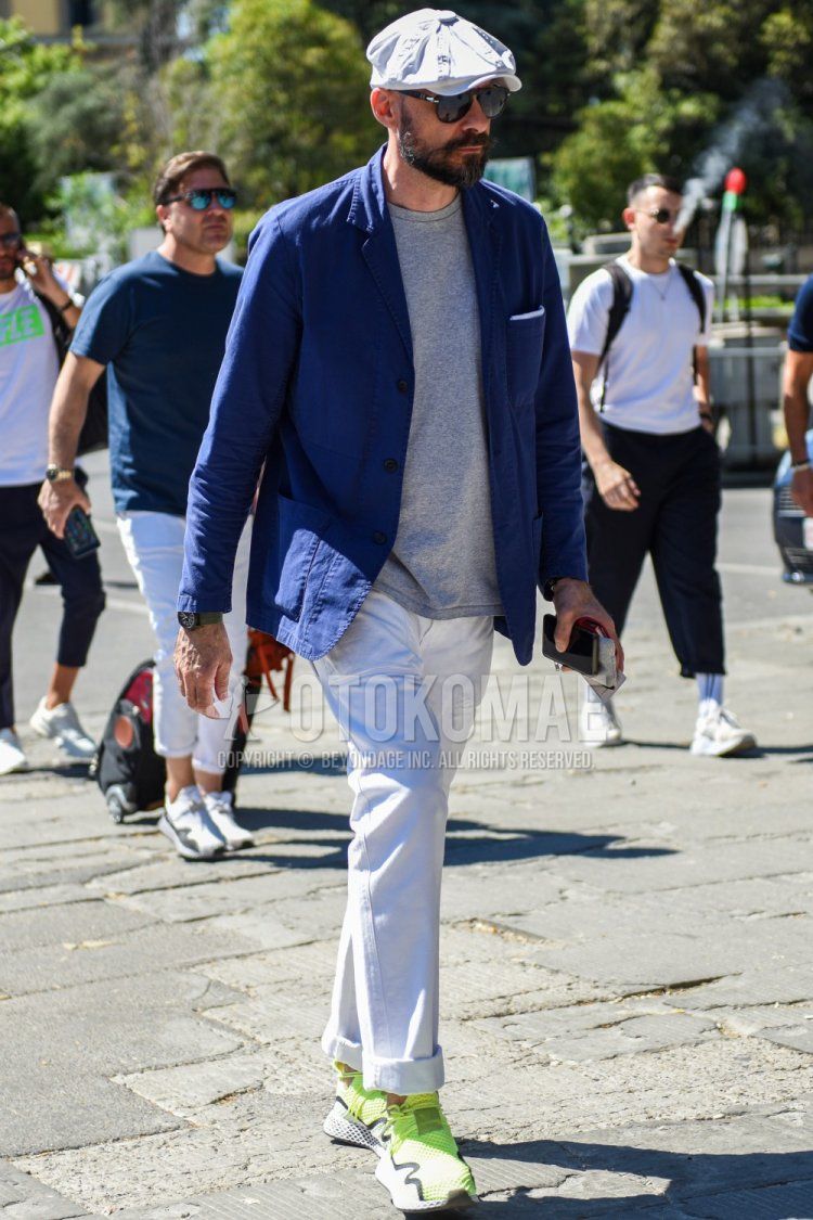 Men's spring/summer coordinate and outfit with plain white cap, plain black sunglasses with teardrops, plain navy tailored jacket, plain gray t-shirt, plain white cotton pants, and yellow-cut sneakers.