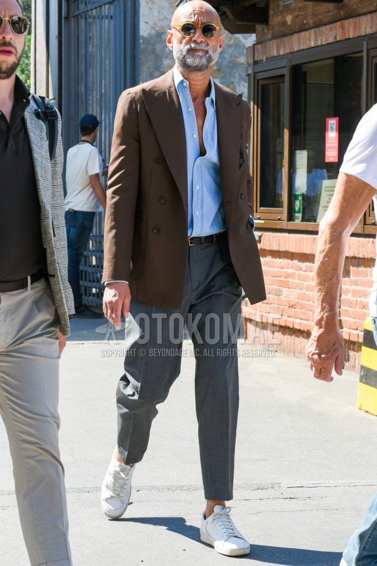 Men's spring/summer coordinate and outfit with plain yellow sunglasses, plain brown tailored jacket, plain light blue shirt, plain brown leather belt, plain gray slacks, and white low-cut sneakers.