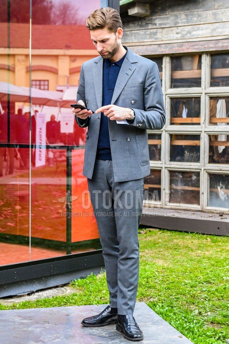 Men's spring and fall coordinate and outfit with plain gray polo shirt, plain green socks, black coin loafer leather shoes, and plain gray suit.