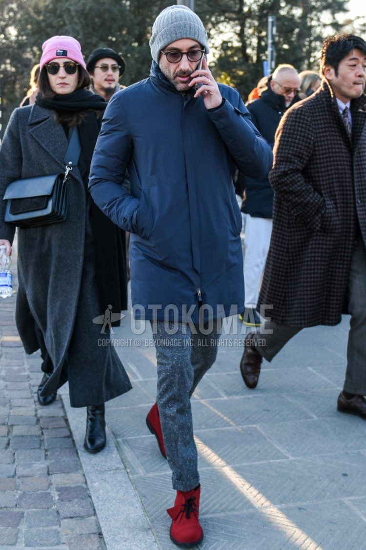 Men's fall/winter outfit with plain gray knit cap, plain black Boston sunglasses, plain navy down jacket, plain navy stainless steel coat, plain gray slacks, plain gray cropped pants, and red chukka boots.