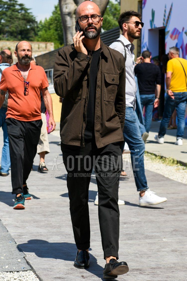 Men's spring and summer coordinate and outfit with plain black glasses, plain brown shirt jacket, plain black t-shirt, plain black ankle pants, plain black slacks, and black coin loafer leather shoes.