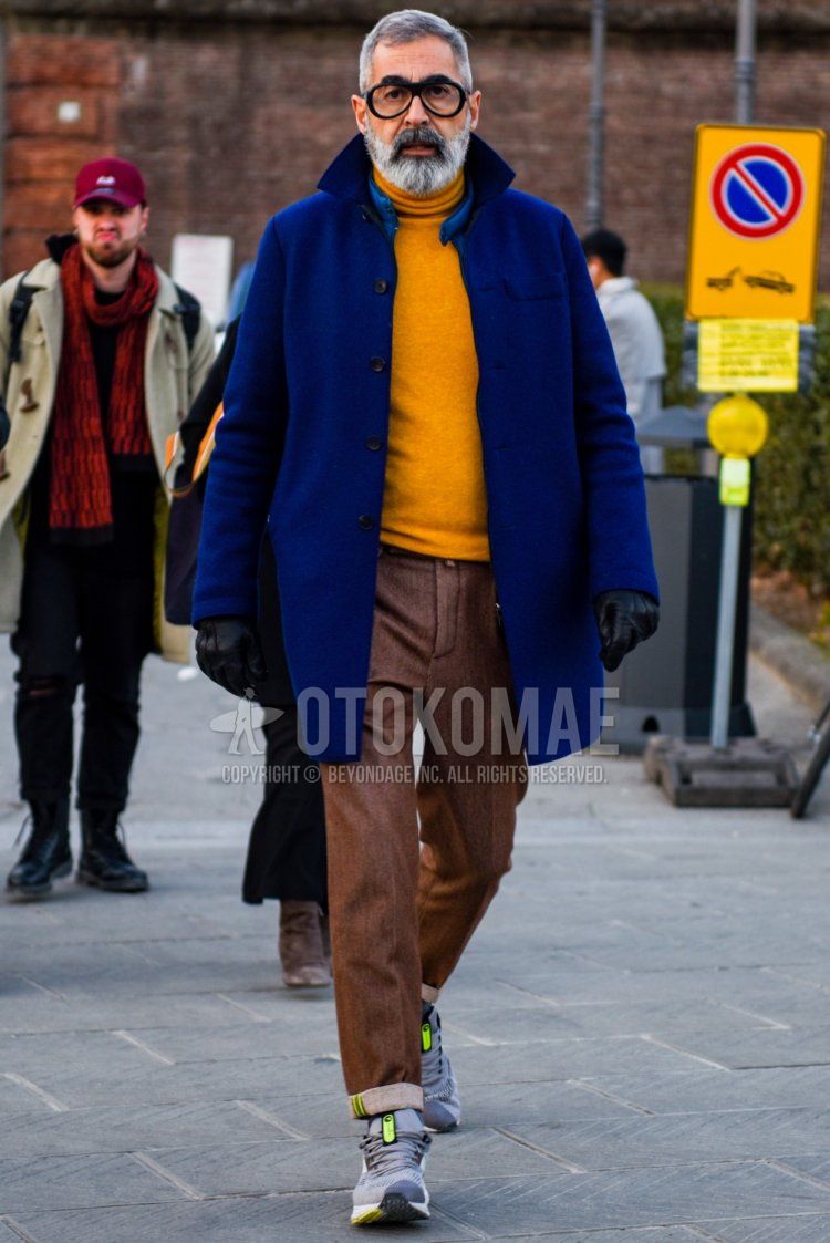 Men's fall/winter coordinate and outfit with plain black glasses, plain blue stainless steel collar coat, plain yellow turtleneck knit, plain brown slacks, and gray low-cut sneakers.
