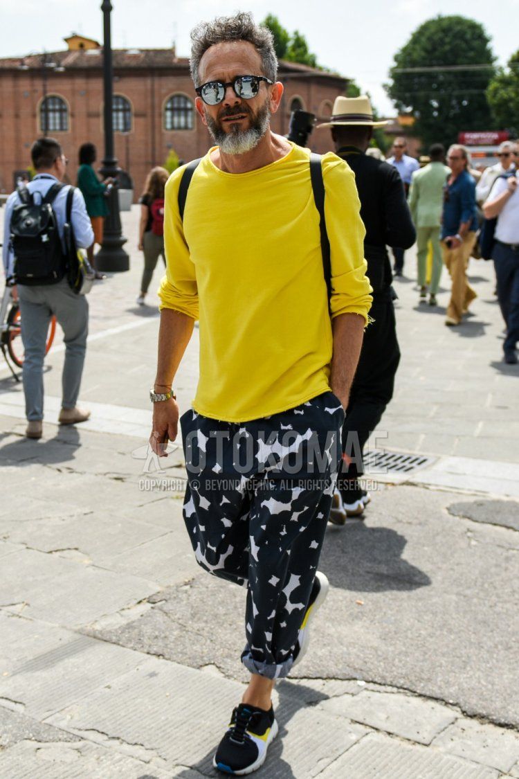 Men's spring, summer, and fall coordinate and outfit with plain black and silver sunglasses, plain yellow t-shirt, black bottom cotton pants, and black low-cut sneakers.