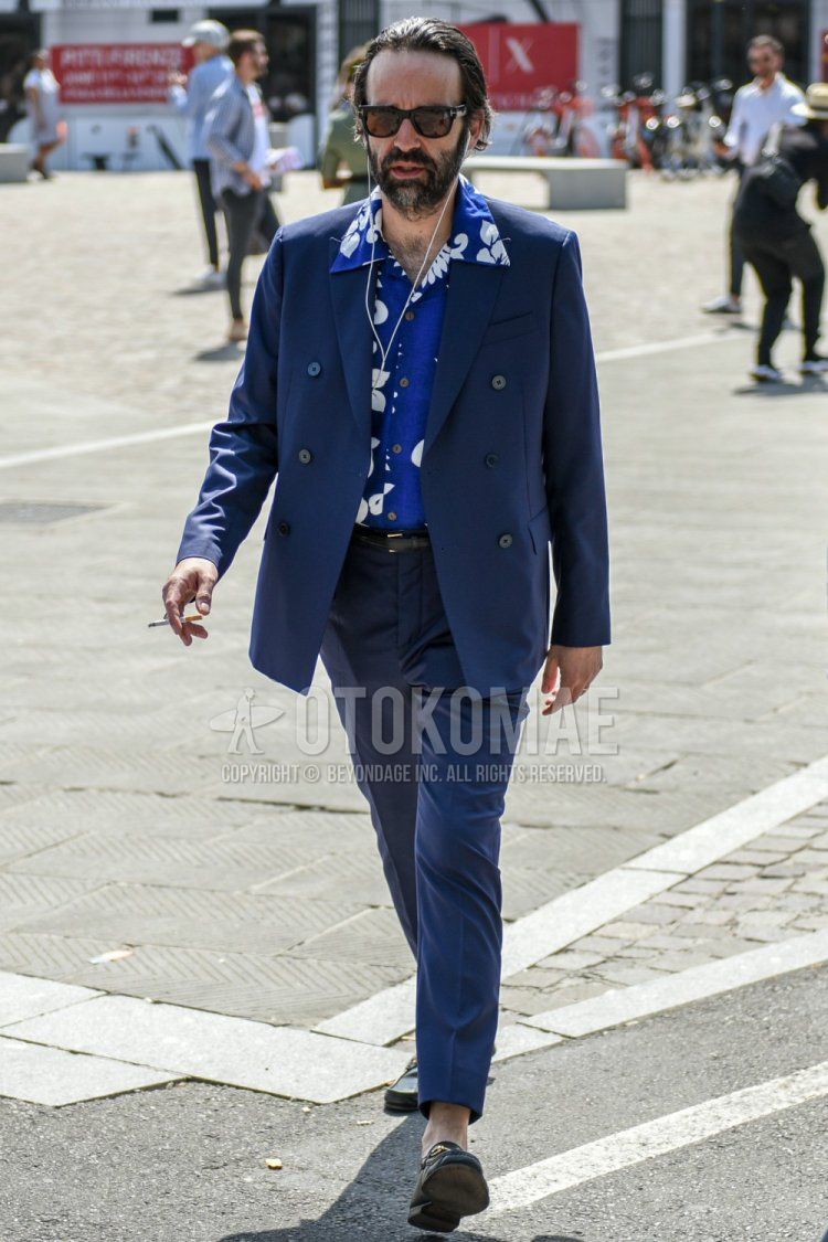 Men's spring/summer/autumn coordinate and outfit with Tom Ford plain black sunglasses, blue top/inner shirt, plain black leather belt, black bit loafer leather shoes, and plain navy suit.
