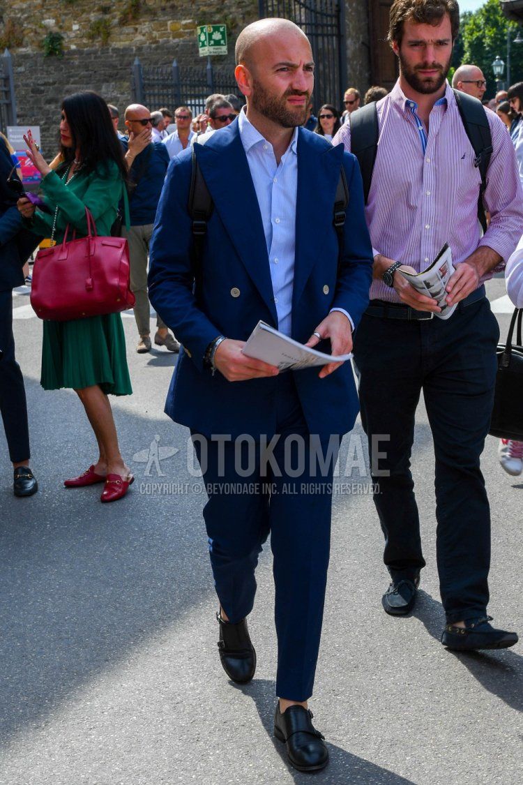 Men's spring, summer, and fall coordination and outfit with plain light blue shirt, black monk shoes leather shoes, and plain navy suit.