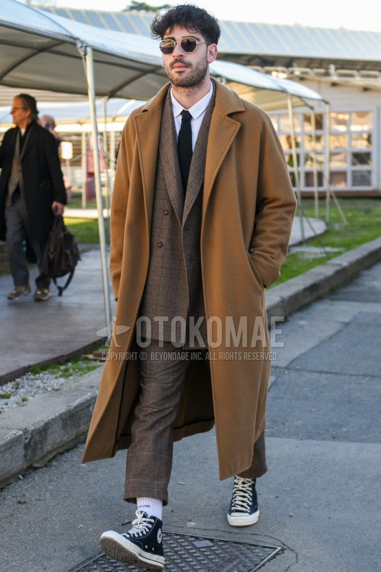 Men's fall/winter outfit and outfit with plain gold sunglasses, plain beige chester coat, plain white shirt, white one-pointed socks, black high-cut Converse All Star sneakers, brown checked suit, and plain black tie.