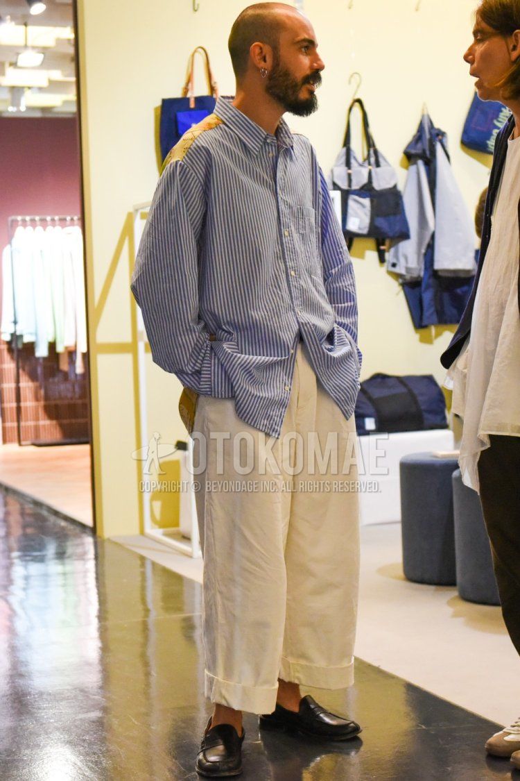 Summer/spring men's coordinate and outfit with blue striped shirt, plain beige chinos and black coin loafer leather shoes.