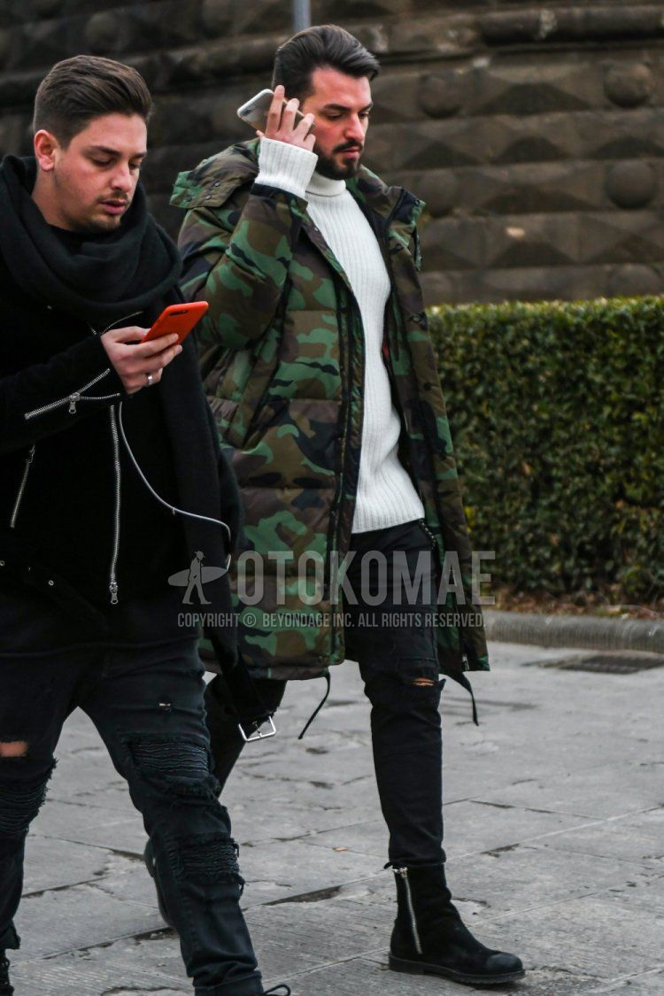 Men's winter coordinate and outfit with green camouflage down jacket, plain white turtleneck knit, plain black damaged jeans, and black boots.