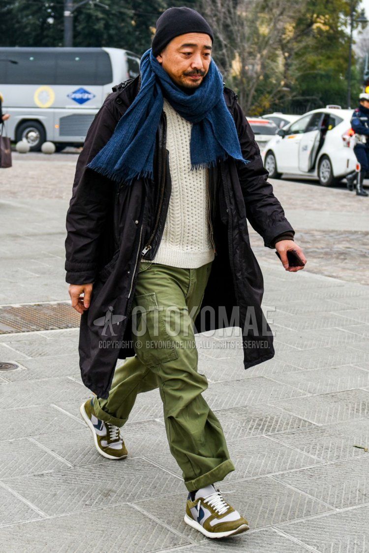Winter men's coordinate and outfit with solid black knit cap, solid black hooded coat, solid white sweater, solid green cargo pants, solid green wide-leg pants, and white low-cut sneakers from Val Sport.