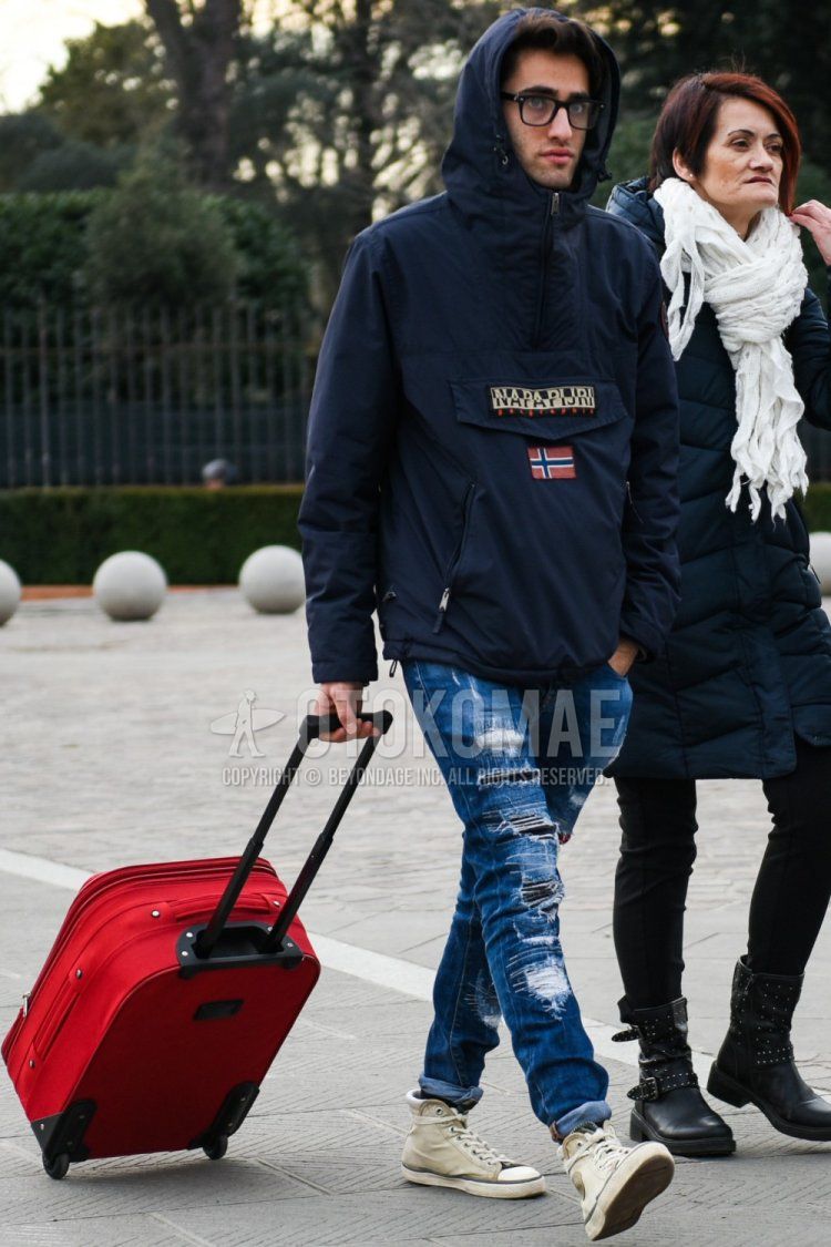 Men's fall/winter coordinate and outfit with plain black glasses, Napapilli plain navy windbreaker, plain blue damaged jeans, beige high-cut sneakers, and plain red suitcase.