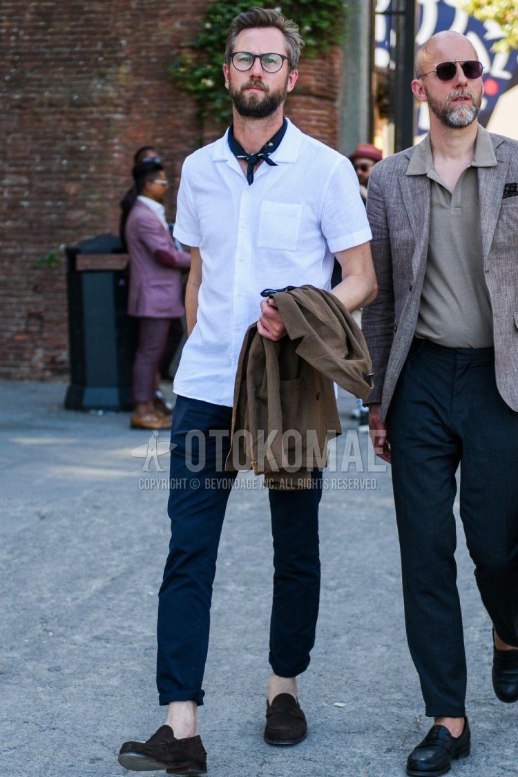 Summer men's coordinate and outfit with plain black glasses, black stole bandana/neckerchief, short sleeves open collar plain white shirt, plain navy chinos, suede brown coin loafer leather shoes.