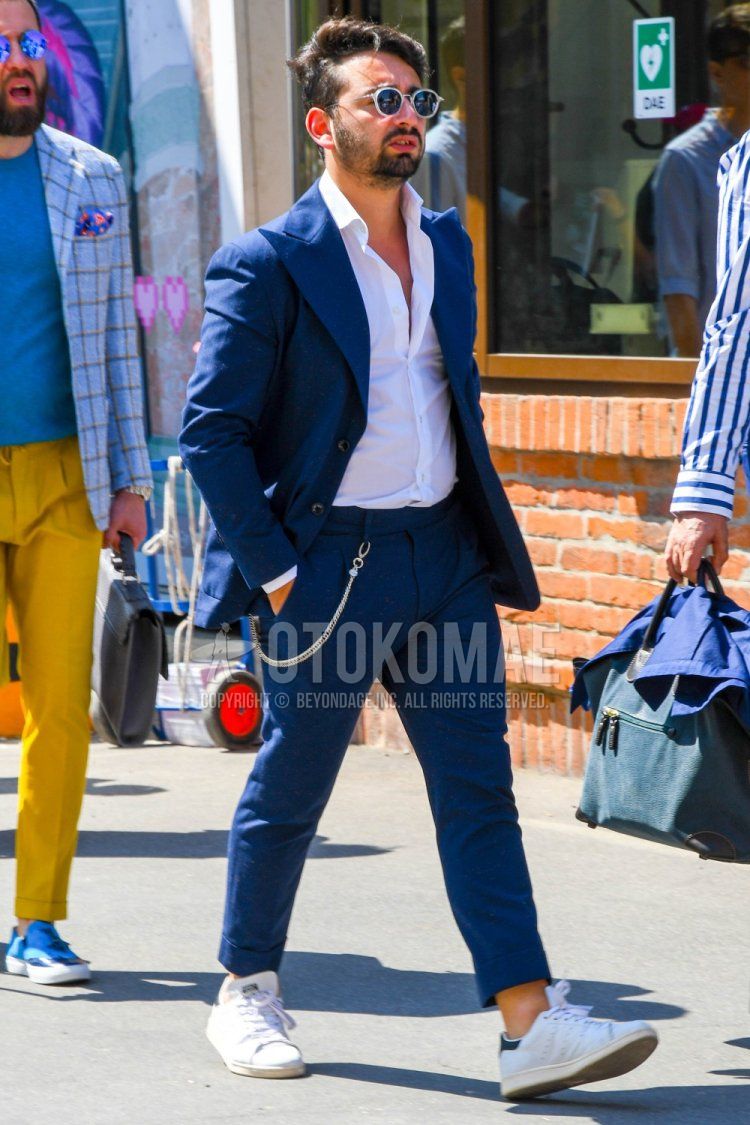 Men's spring, summer, and fall outfits and outfits with plain white sunglasses, plain white shirt, Adidas Stan Smith white low-cut sneakers, and plain navy suit.