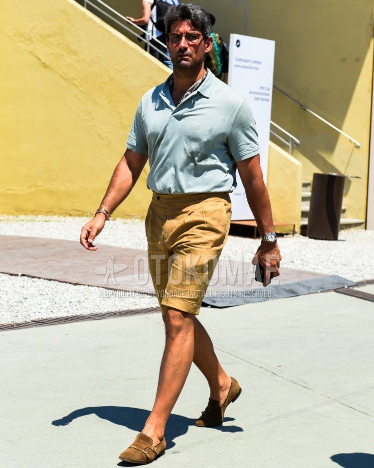 Summer/spring men's coordinate and outfit with brown tortoiseshell glasses, brown stole bandana/neckerchief, plain blue polo shirt, plain beige shorts, brown monk shoes leather shoes, brown suede shoes leather shoes.