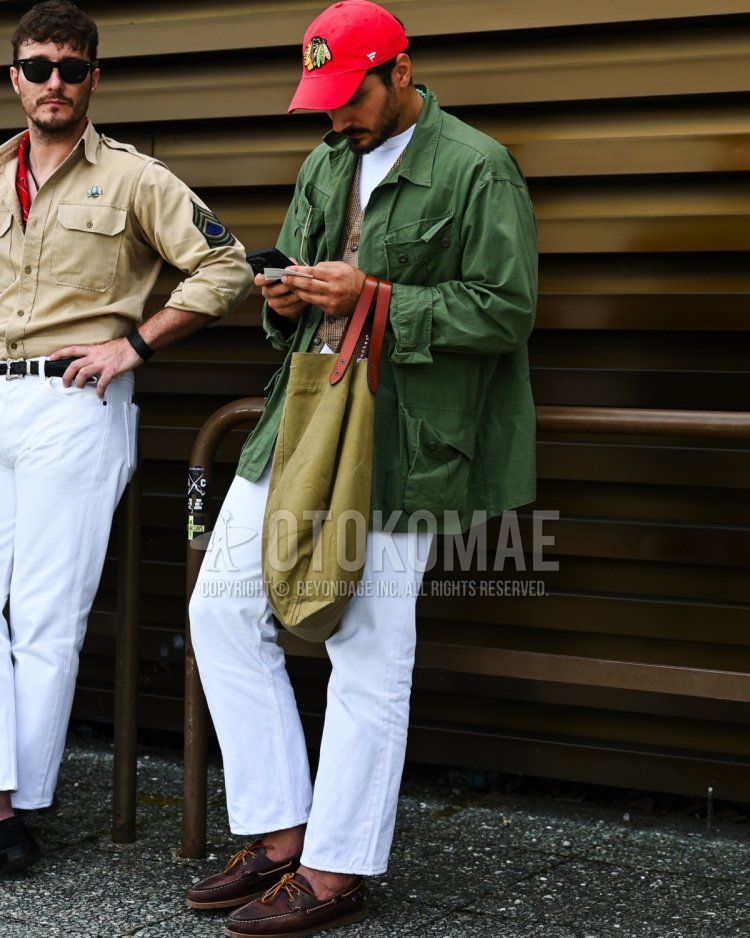 Red one-pointed baseball cap, olive green solid color military jacket (except MA-1, M-65), white solid color T-shirt, beige solid color casual vest, white solid color denim/jeans, brown moccasin/deck shoes leather shoes, beige solid color tote bag Men's Fall/Summer/Spring Codes and Outfits.