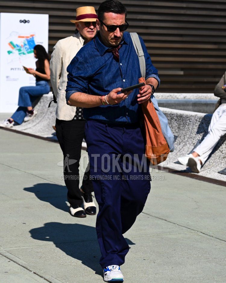 Men's spring/summer/fall outfit with plain black sunglasses, brown all-over bandana/neckerchief, plain navy shirt, plain navy cargo pants, white low-cut sneakers, and plain brown tote bag.