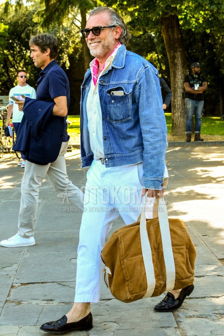 Men's spring/summer/fall outfit with solid color sunglasses, red stole bandana/neckerchief, solid color blue denim jacket, solid color white shirt, solid color white cotton pants, brown coin loafer leather shoes, solid color beige briefcase/handbag.