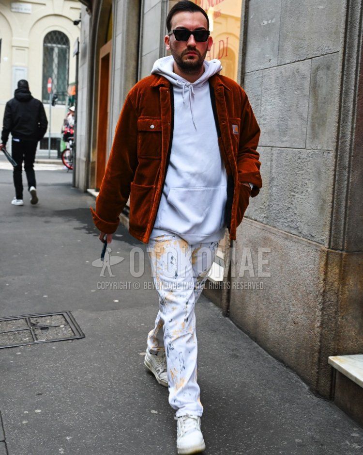 Men's fall/winter coordinate and outfit with plain black sunglasses, plain brown coveralls, plain white hoodie, white bottoms denim/jeans, and white low-cut sneakers.
