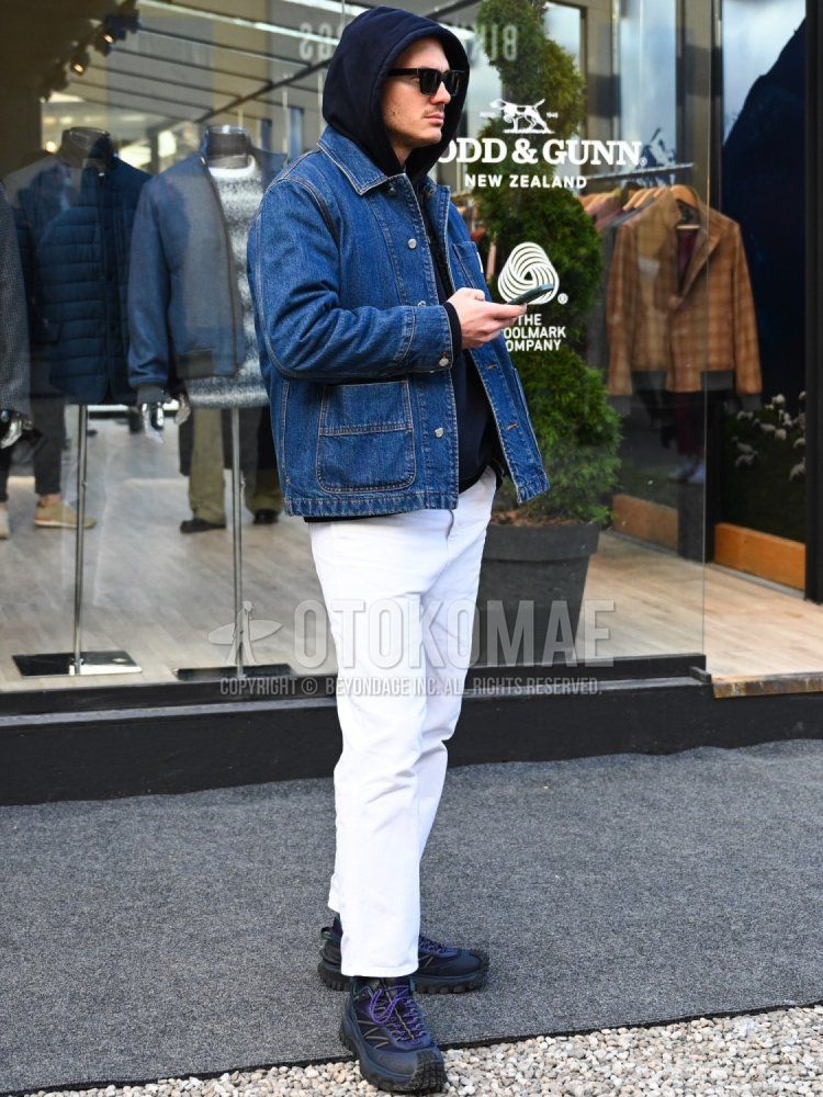 Men's fall/winter outfit with plain black sunglasses, plain blue denim jacket, plain brown hoodie, and Moncler Grenoble navy low-cut sneakers.