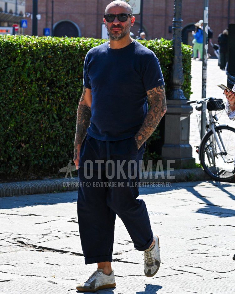 Men's spring and summer coordinate and outfit with plain black sunglasses, plain navy t-shirt, plain navy slacks, and white low-cut sneakers.