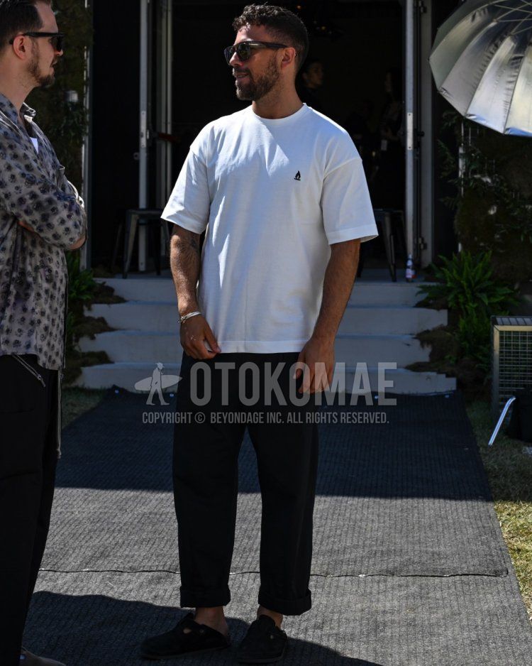 Men's spring/summer coordinate and outfit with plain black sunglasses, white one-pointed t-shirt, plain black denim/jeans, and black Gurkha sandals.