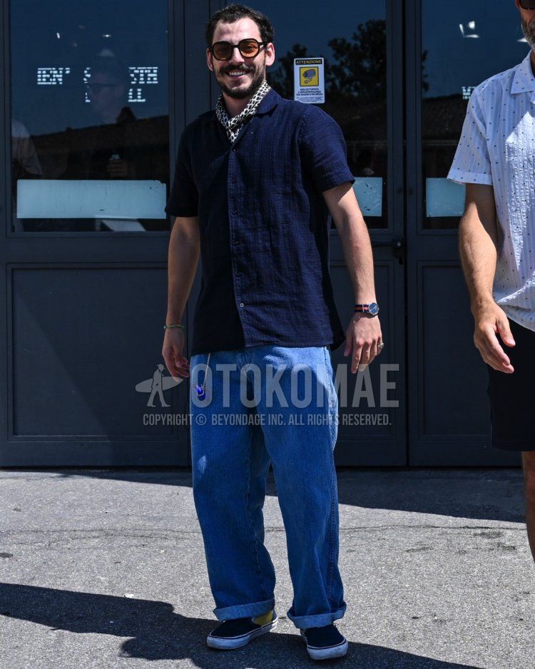 Men's spring/summer coordinate and outfit with plain brown sunglasses, all-over white bandana/neckerchief, plain navy shirt, plain light blue denim/jeans, and blue low-cut sneakers.