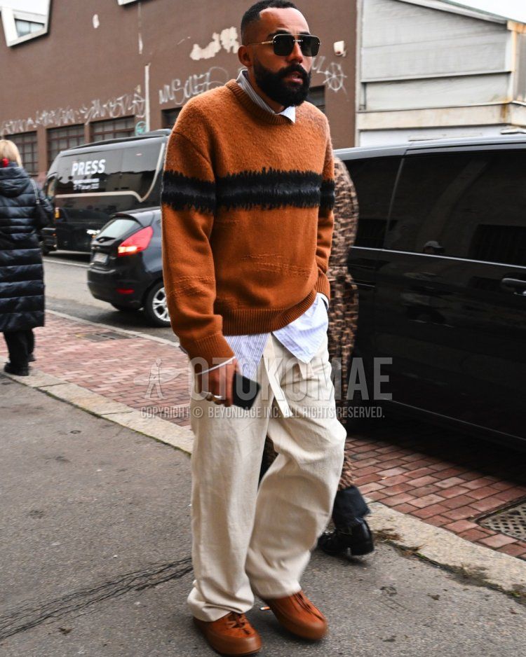 Men's fall/winter outfit with plain gold sunglasses, blue striped shirt, brown top/inner sweater, plain white tape belt, plain white cotton pants, and brown low-cut sneakers.